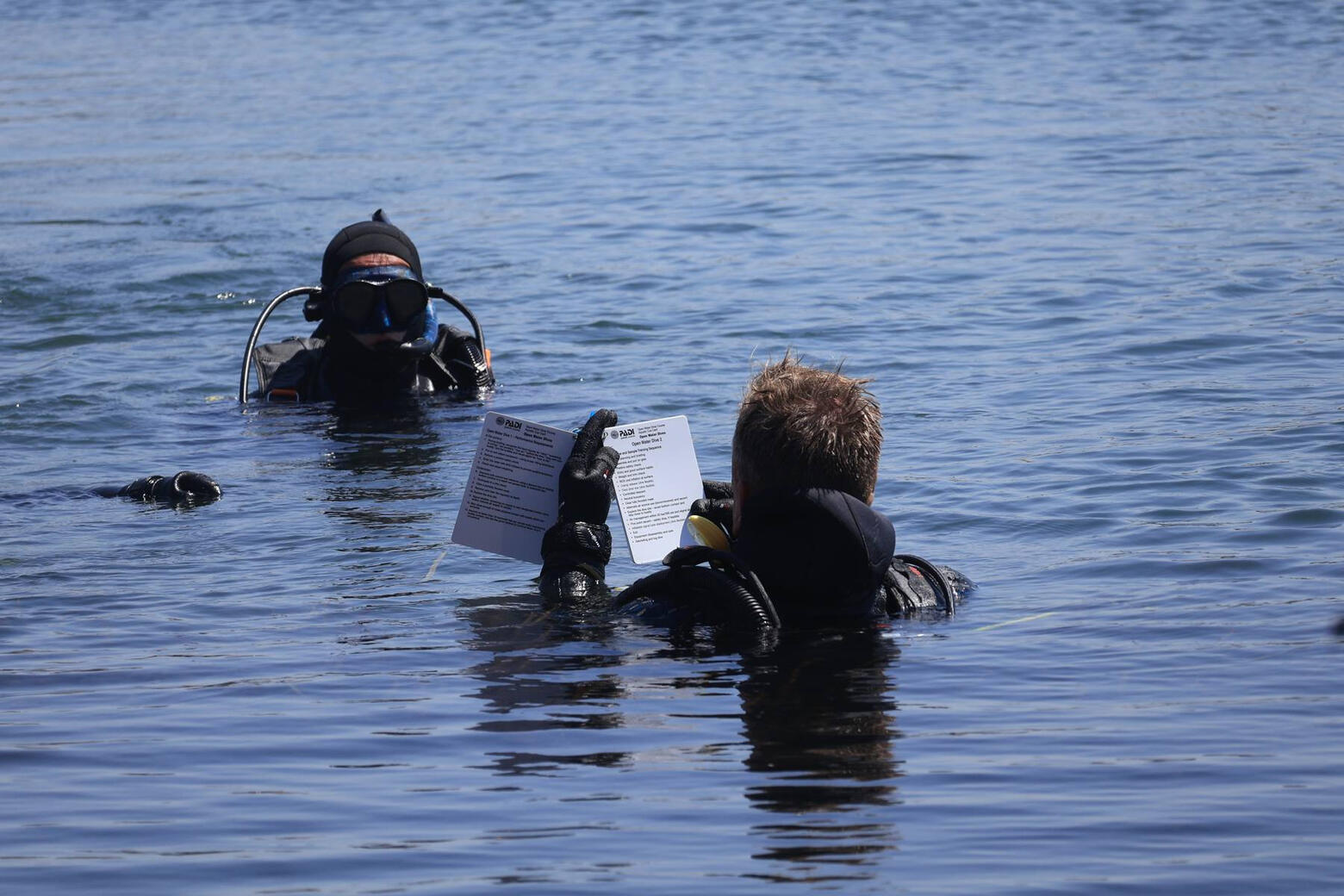 Jason briefing a diver at the surface with a dive slate Jason briefing a diver at the surface with a dive slate